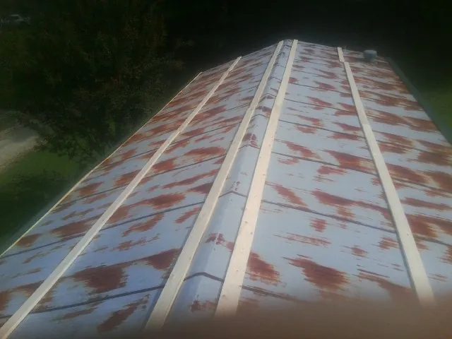 Rusted metal roof panels with new wood purlins before replacement — Storm Damage Roof Repair in West Finley by Roofing Brothers