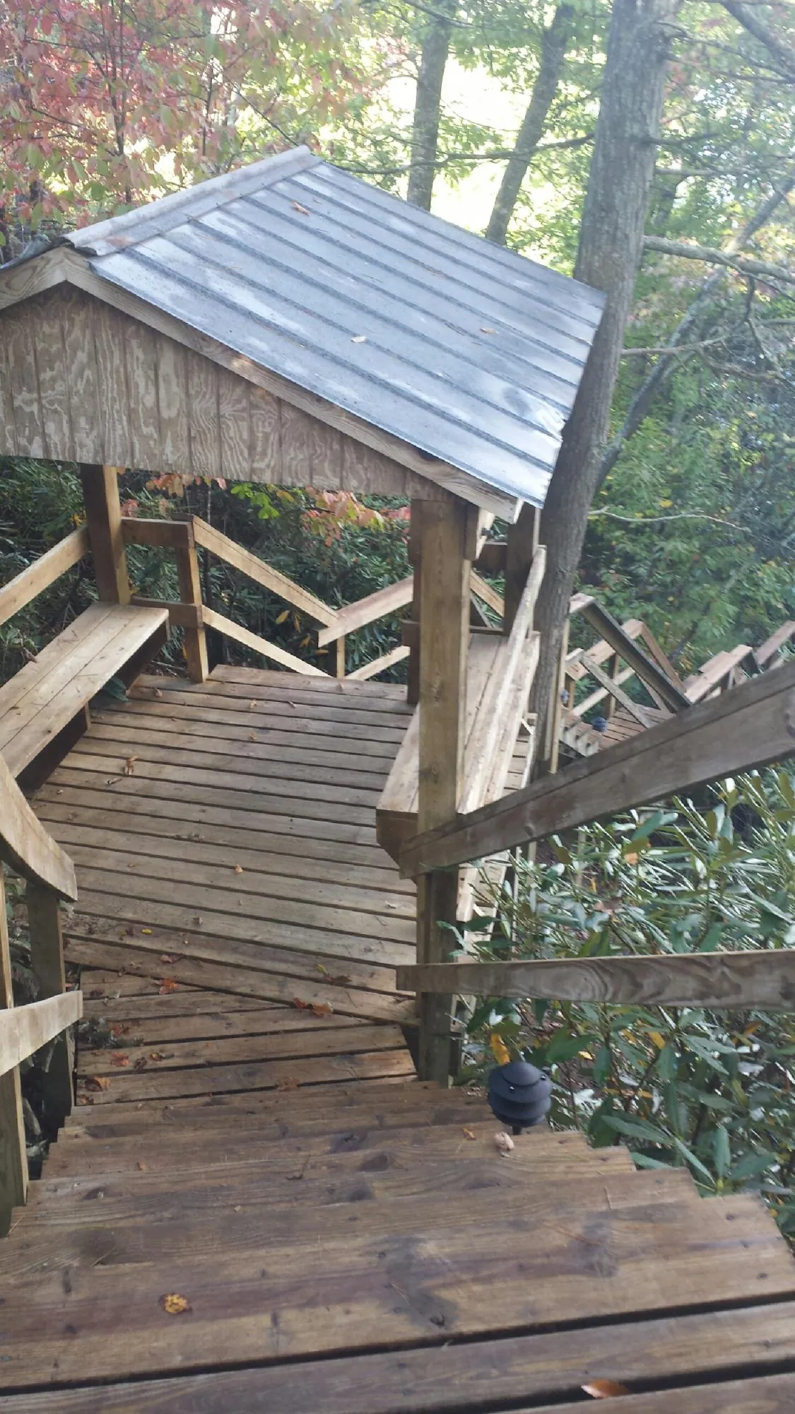 Metal roofed shelter over wooden steps on a wooded walkway — Skylight Repair & Installation work by our crew in West Finley