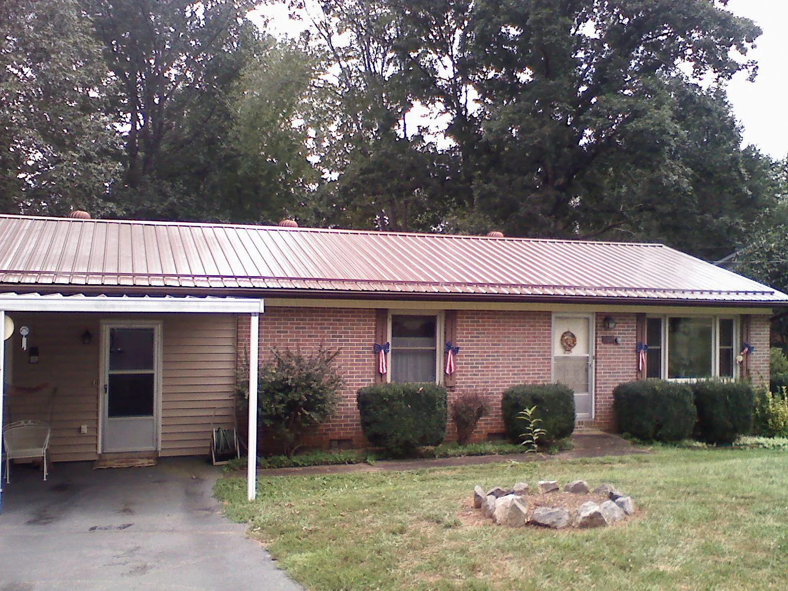 Bronze metal roof and carport on a brick ranch home — Roof Repair work by our crew in West Finley