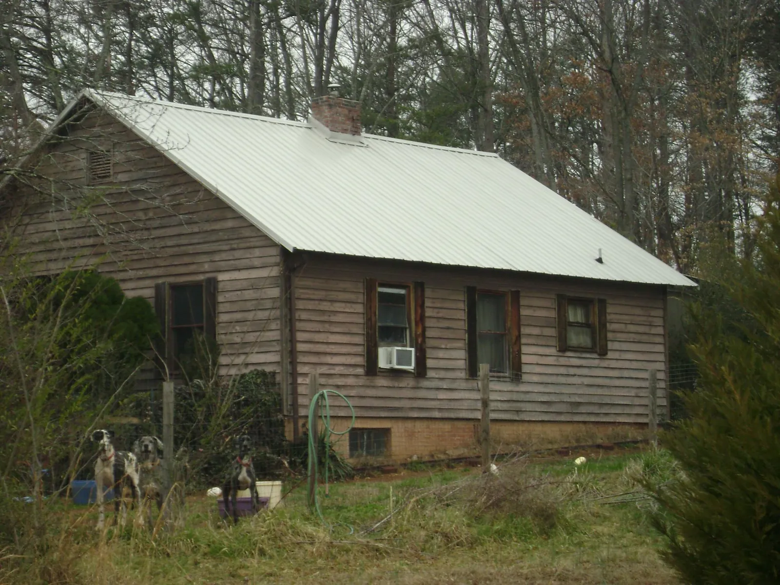 White metal roof on an old wood sided farmhouse, from a Metal Roof Installation job in West Finley